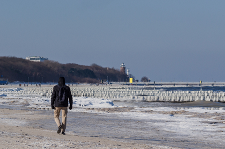 WINTER ATTACK ON THE SEA SHORE - Man on a winter frozen beach in Kolobrzegの写真素材