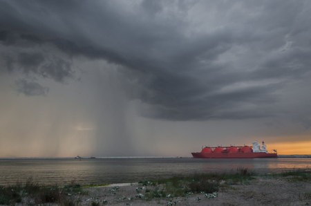 LNG TANKER - Rain and stormy dramatic clouds over a gas terminal in Swinoujscieの写真素材