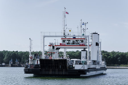 SWINOUJSCIE, WEST POMERANIAN / POLAND - 2018: Cars and people on a ferry crossing the riverのeditorial素材