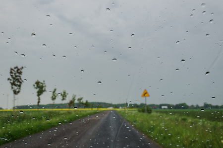 RAINY WEATHER AND DROPS OF RAIN ON THE GLASS - Rural landscape on a cloudy dayの写真素材