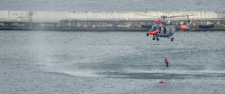 SEA HELICOPTER AND FROGMAN - Naval rescue machine over the breakwater of the sea port