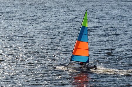 REGATTA IN SUNNY RAYS - Sailboat on the waves of the lake