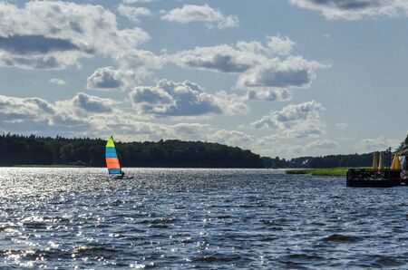 REGATTA IN SUNNY RAYS - Sailboat on the waves of the lakeの写真素材