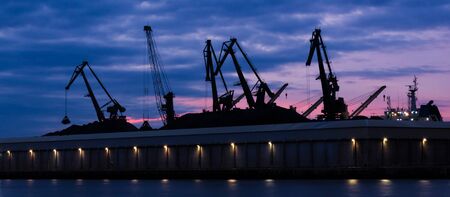 TRANSSHIPMENT TERMINAL - Port cranes on the coal quay in Gdynia at sunriseの写真素材