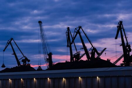 TRANSSHIPMENT TERMINAL - Port cranes on the coal quay in Gdynia at sunriseの写真素材