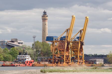 SEAPORT - A red ship moored at the quay, transshipment terminal and lighthouse