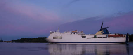 PASSENGER FERRY - The ship sails to a terminal in a seaportの写真素材