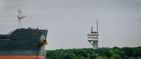 BULK CARRIER AND TRAFFIC CONTROL TOWER AT SEA - Freighter entering a seaportの写真素材
