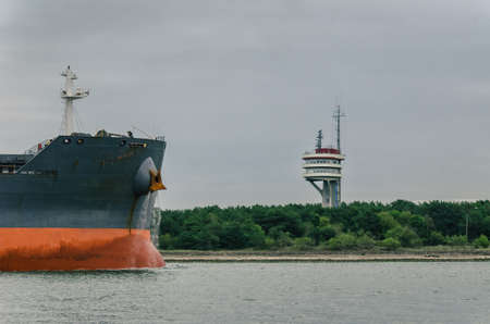 BULK CARRIER AND TRAFFIC CONTROL TOWER AT SEA - Freighter entering a seaportの写真素材