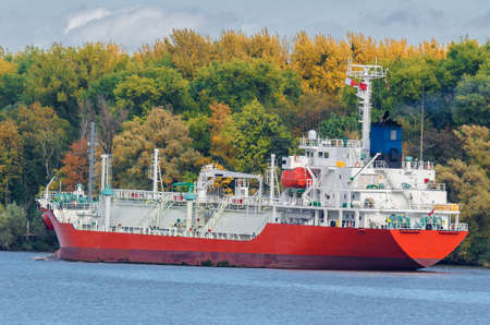 LPG TANKER - The red ship follows the fairway in the channel to the portの写真素材
