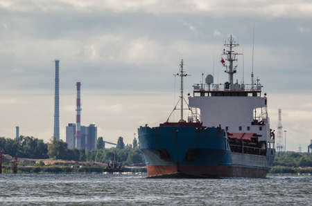 MERCHANT VESSEL - Ship on the background of the coast with industrial chimneysの写真素材