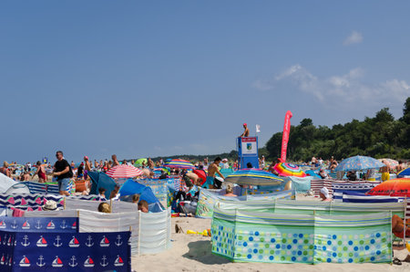 SARBINOWO, WEST POMERANIAN / POLAND - 2021: Holidaymakers relacreation on sunny sea beach under the care of a lifeguardのeditorial素材