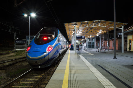 KOLOBRZEG, WEST POMERANIAN / POLAND - 2021: Express train waiting for passengers at platform at the railway stationのeditorial素材