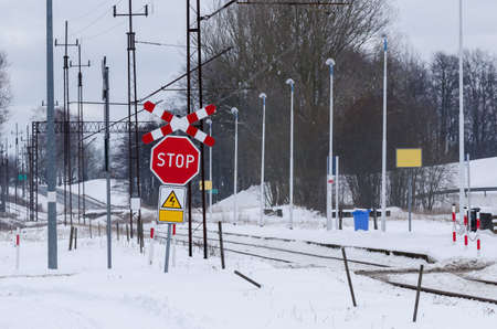 STOP SIGN - Railroad crossing without barriers in a snowy village stationの写真素材