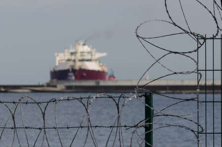 PROTECTING SITE - Separating seaport with fence and razor wireの写真素材