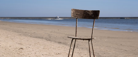 CHAIR ON THE BEACH - An abandoned piece of furniture on the seashoreの写真素材