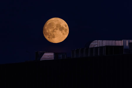 MOON - Earth satellite over the roof of a shopping mall and against the night skyの写真素材