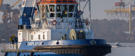 SWINOUJSCIE, WEST POMERANIAN - POLAND - 2022: The tug boat is sailing against the background of the seaportのeditorial素材