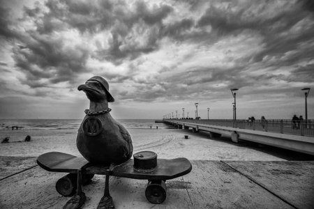 KOLOBRZEG, WEST POMERANIAN - POLAND - 2023: Marian seagull figurine at promenade and walking pier on a cloudy day by the seaのeditorial素材