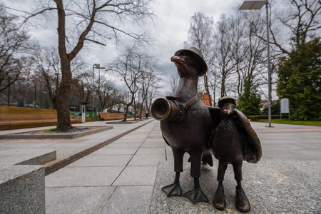 KOLOBRZEG, WEST POMERANIAN - POLAND - 2023: Marian seagull figurine with a camera and family on a walking promenade on a cloudy dayのeditorial素材