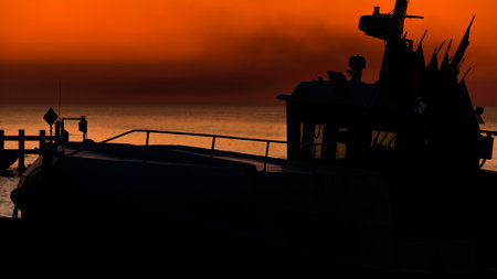 SUNSET BY THE SEA - Fishing boats on coast in the light of evening sunの写真素材