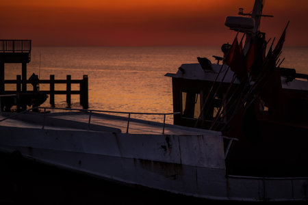 SUNSET BY THE SEA - Fishing boats on coast in the light of evening sunの写真素材