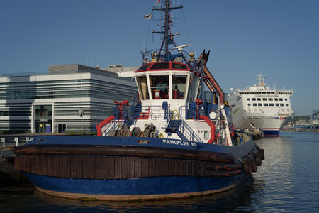 GDYNIA, POMERANIAN - POLAND - 2023: Tugboat at quay and a passenger ferry moored at the terminal
