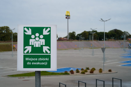 KOLOBRZEG, WEST POMERANIAN - POLAND - JULY 30, 2023: A sign with the inscription EVACUATION ASSEMBLY POINTのeditorial素材