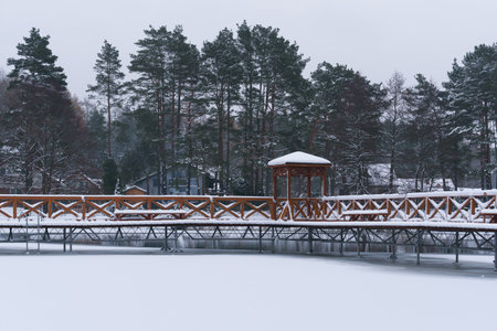 WINTER ATTACK - A frozen lake and a wooden recreation pier covered with snowの写真素材