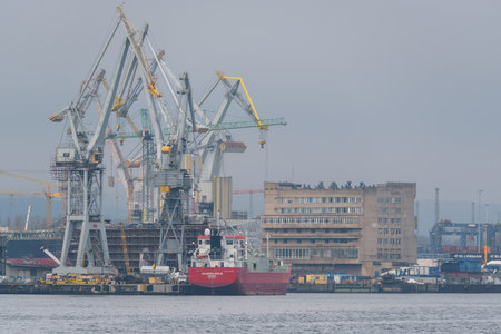 GDYNIA, POMERANIAN REGION - POLAND - MARCH 13,2024: Cranes and ships in a misty shipyard