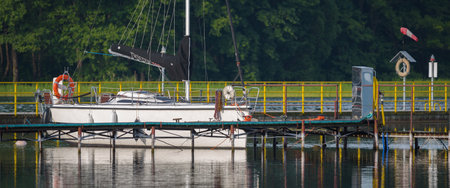 CZAPLINEK, WEST POMERANIAN - POLAND - JUNE 14, 2024: LANDSCAPE BY THE LAKE - A sailboat moored in...