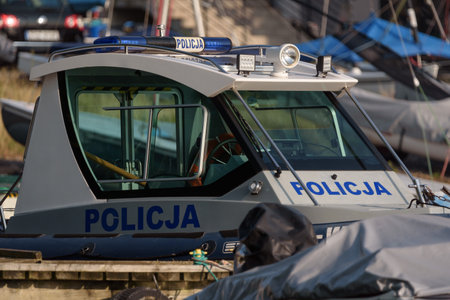 SZCZECINEK, WEST POMERANIAN - POLAND - AUGUST 20, 2024: A police patrol boat is moored in a marina on the lakeのeditorial素材