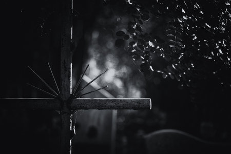 CEMETERY - An old steel cross on a tombstoneの写真素材