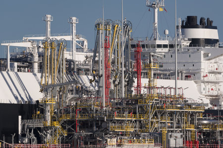 LNG TERMINAL AND GAS TANKER - A black ship moored at the port quay