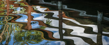 SUMMERTIME AT LAKE - Walking pier on the lake and its mirror reflection in water