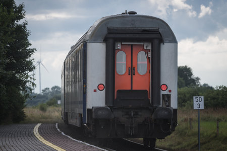 PASSENGER TRAIN - The last carriage of an intercity train passing through a small rural station