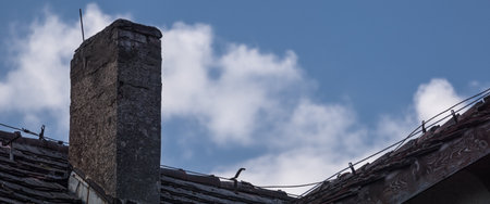 CHIMNEY ON THE ROOF - Brick architectural element of an old house