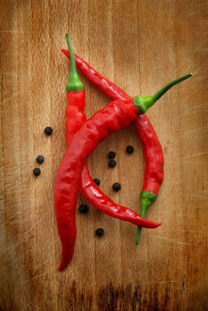 Red chili peppers over a wooden background