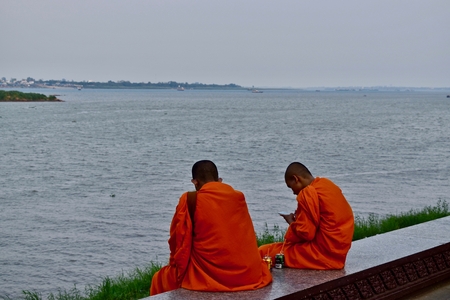 Two monks and the Mekong river in Phnom Penh, Cambodia.