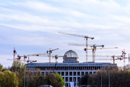 Many tower cranes build a house beyond the city square.の写真素材