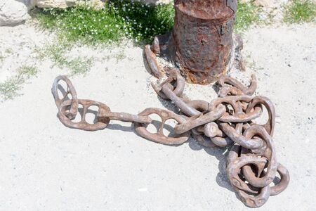 A large rusty chain lies on the pier.の写真素材