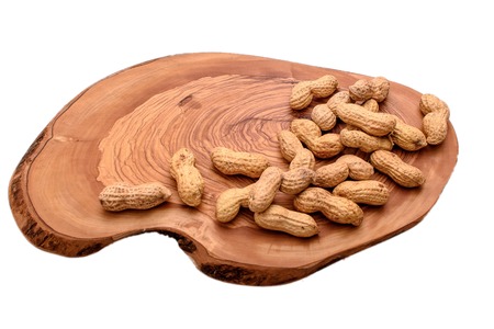 Peanuts in a shell on a wooden board isolated on a white background.の写真素材