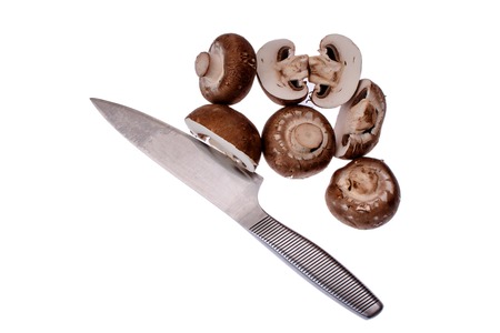 Mushrooms champignons next to lies knife isolated on white background.の写真素材