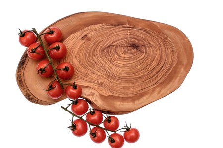Cherry tomatoes lie on a wooden board of drying oil, isolated on white background.の写真素材