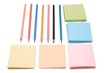 Many colored crowns and colored paper for writing, isolated on white background.