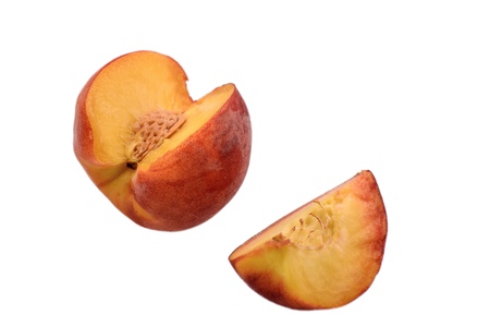 Peaches whole and sliced halves with a bone isolated on white background.の写真素材
