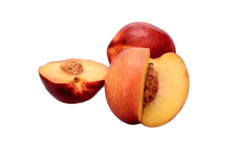 Peaches whole and sliced halves with a bone isolated on white background.の写真素材