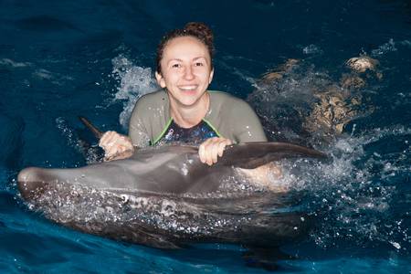 Photo happy girl and dolphin in blue waterの写真素材