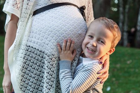 Son hugging his pregnant mother