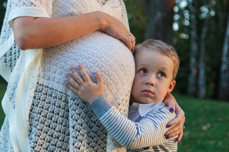 Son hugging his pregnant mother
